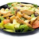 Experience the tasty blend of flavors in Genova's To Go's Chicken Caesar Salad: a delightful bowl of salad with chicken, lettuce, and tomatoes.