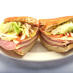 Italian sub stuffed with lettuce, onions, fresh tomato, provolone cheese, and ham from Genova's To Go.