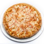 A delicious buffalo chicken pizza from Genova's To Go, with cheese and sauce on a white surface.