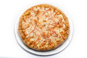 A delicious buffalo chicken pizza from Genova's To Go, with cheese and sauce on a white surface.
