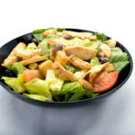 Chicken Caesar Salad from Genova's To Go: Fresh greens, tomato, grilled chicken, and creamy Caesar dressing.