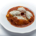 Genova's To Go four stuffed shells topped with melted mozzarella cheese and homemade tomato sauce.