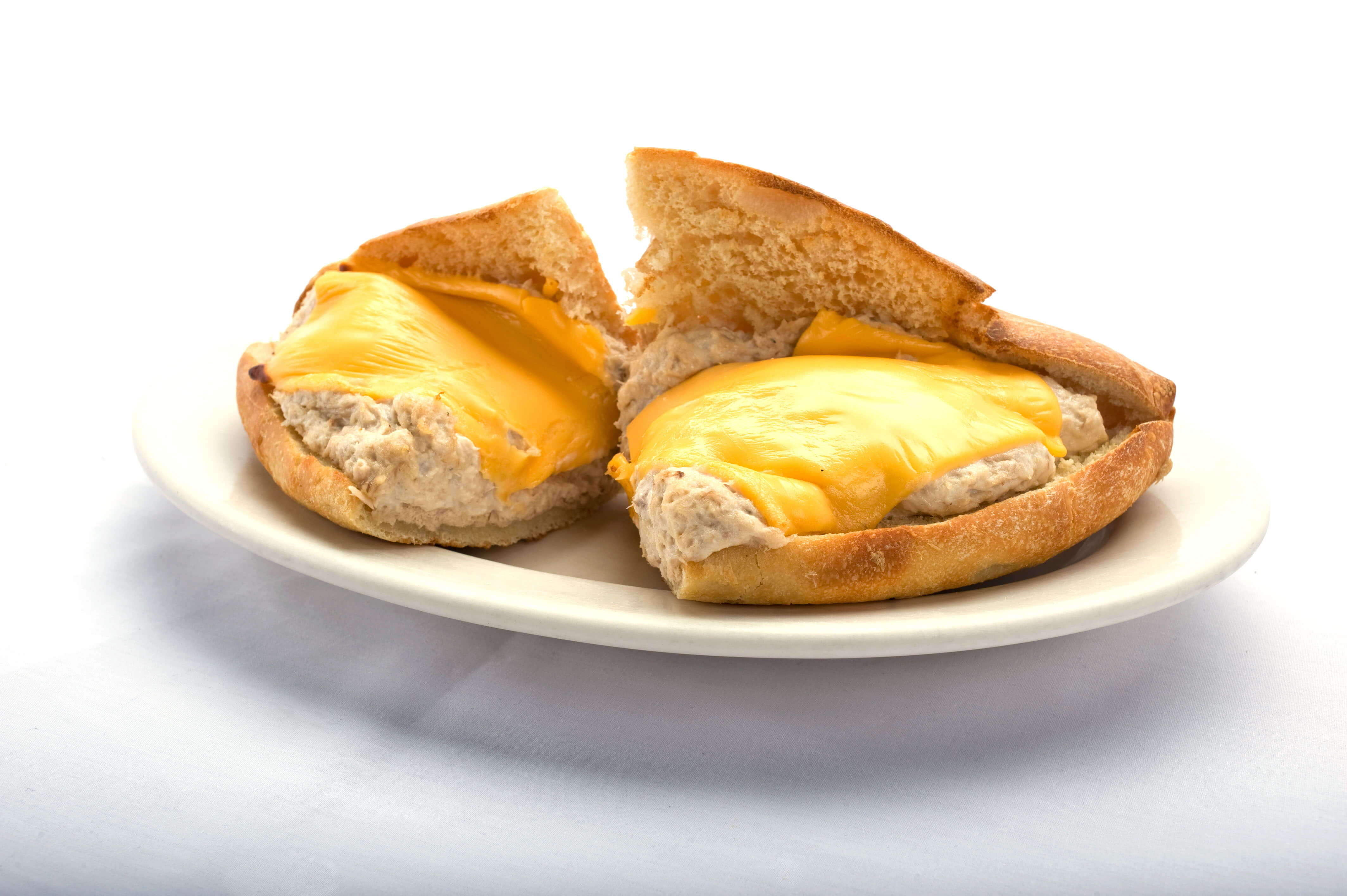 A delicious tuna melt sandwich with cheese on a plate, served from Genova's To Go. Enjoy this mouthwatering treat!