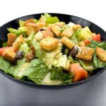 A delicious Caesar salad with croutons and tomatoes. The perfect meal from Genova's To Go.