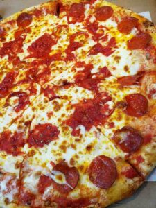 Delicious Genova's To Go pepperoni pizza, topped with mouthwatering cheese and savory pepperoni.