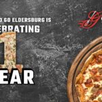 Genova's To Go Eldersburg is celebrating 1 year banner showcasing a Meat Lover's pizza pie.